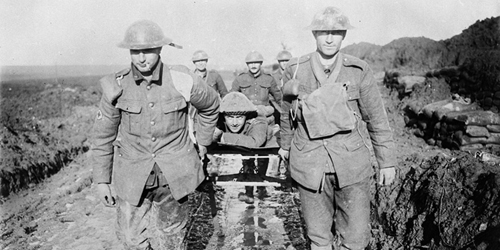 La boue des tranchées rend le transport de ce soldat canadien blessé difficile. Novembre 1916. Mention : Ministère de la Défense nationale / BAC, MIKAN no. 3395820.