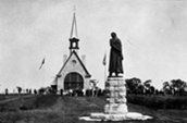 Rassemblement: Monument dédié à Évangeline en face de l'église. / Photo: Ministère de l'Intérieur, Bibliothèque et Archives Canada PA-041958.
