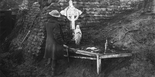 Un Canadien se recueille devant la tombe d’un soldat tué lors de la 2e bataille d’Ypres. Novembre 1917. Mention : Ministère de la Défense nationale / BAC, MIKAN no. 3403359.